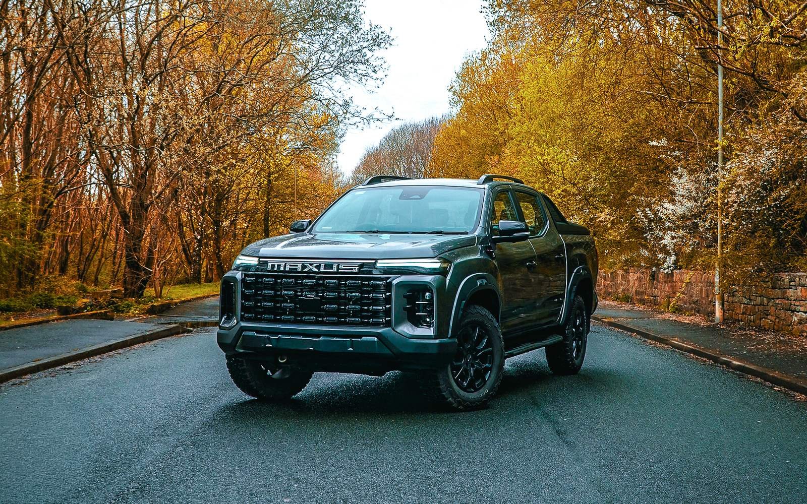 Maxus T60 double cab 4x4 pickup truck on a tree-lined road, available from The Electric Van Company in Rochdale, Leeds and Nelson